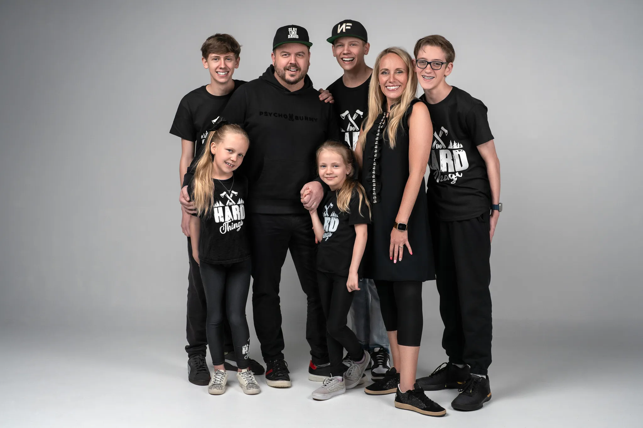 Josh and Ashlee Latimer with their five kids, all in black, in the studio.